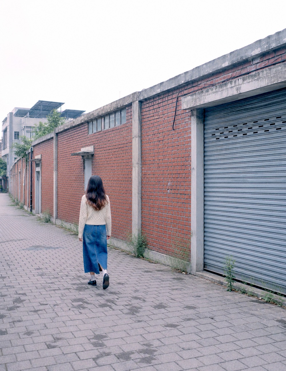 벽돌 담을 따라 걷는 뒷모습
